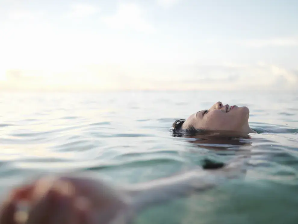 Mujer flotando en el mar.