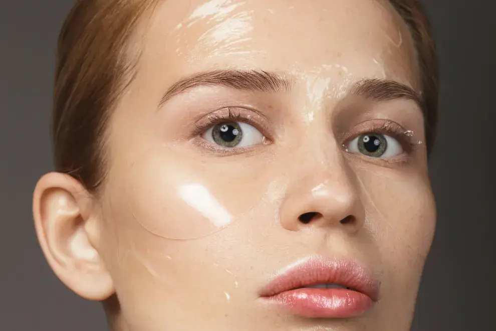 Primer plano de un rostro con geles transparentes en la piel.