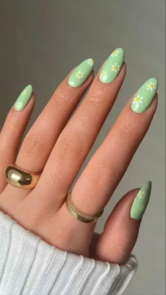 Foto de una mano con esmalte de uñas verde.