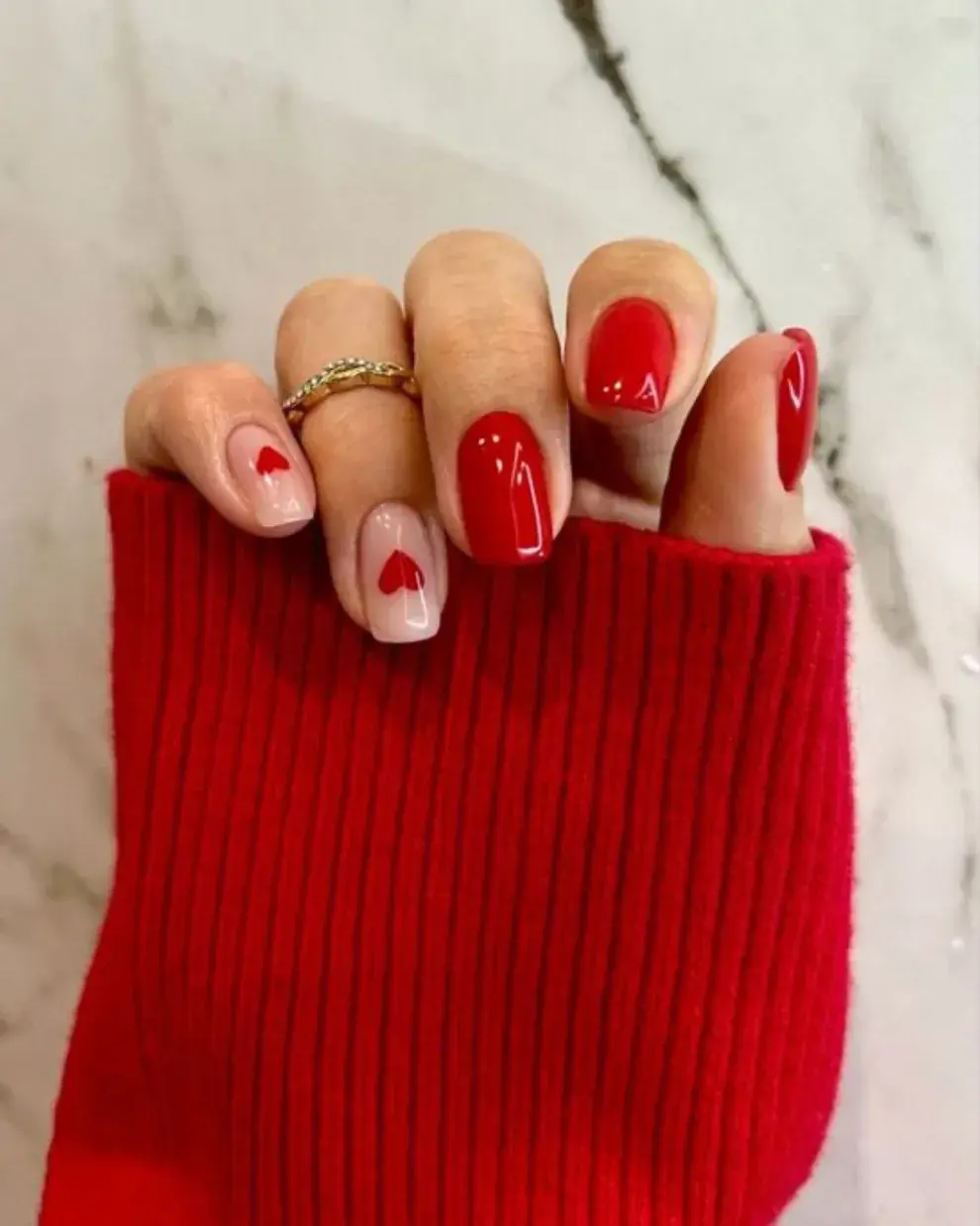 Foto de una mano con las uñas pintadas de rojo.