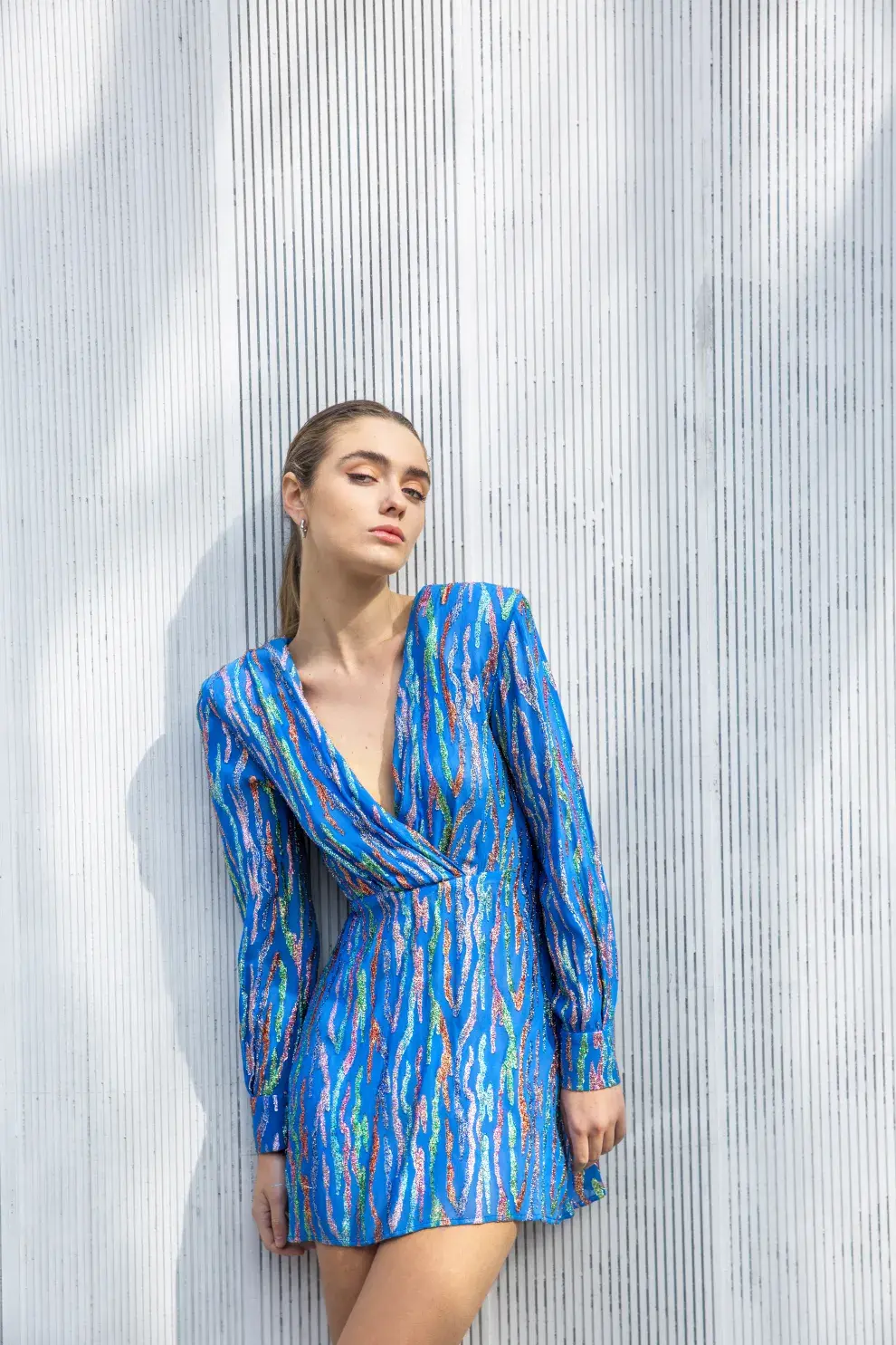 Una mujer posando con un vestido azul de brillos