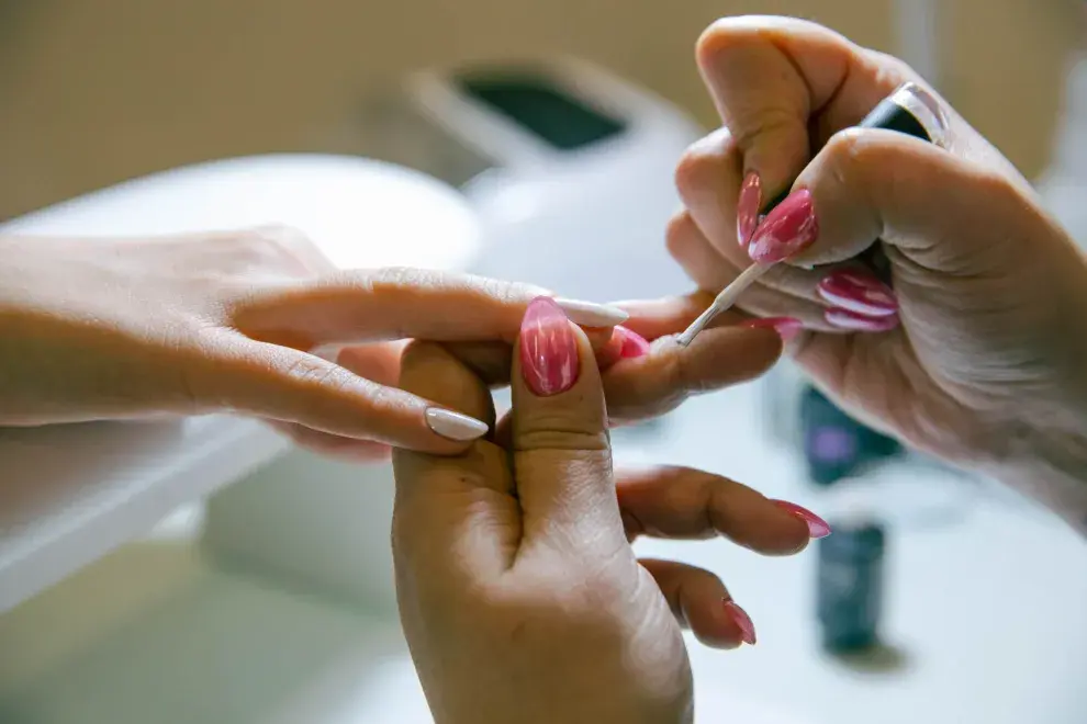 Foto de una mano haciéndose manicura.