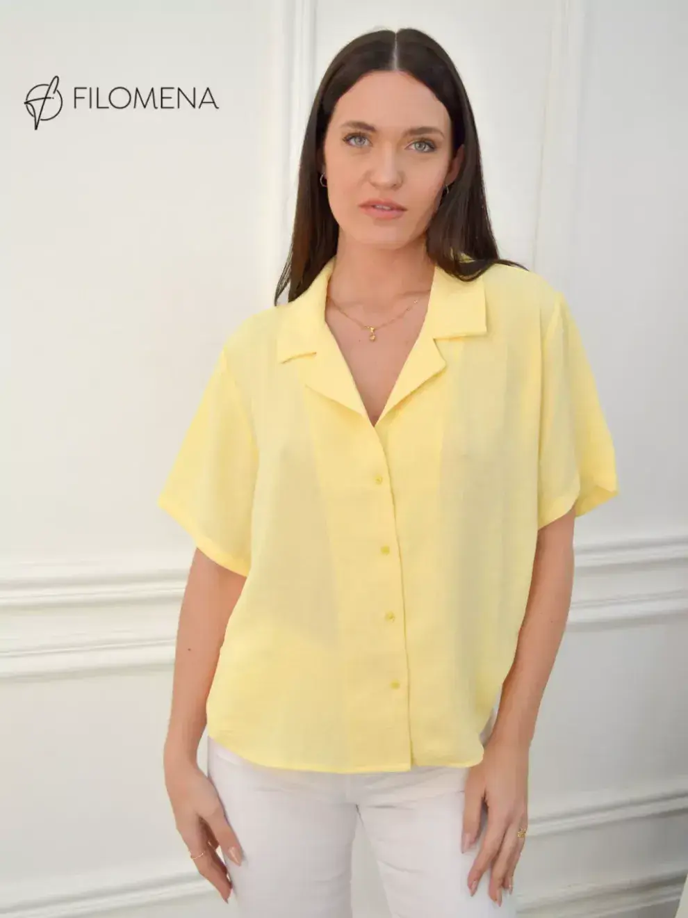 Foto de una modelo mujer usando una camisa amarillo pastel.