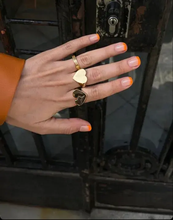 Foto de una mano de mujer con manicura francesa de color.