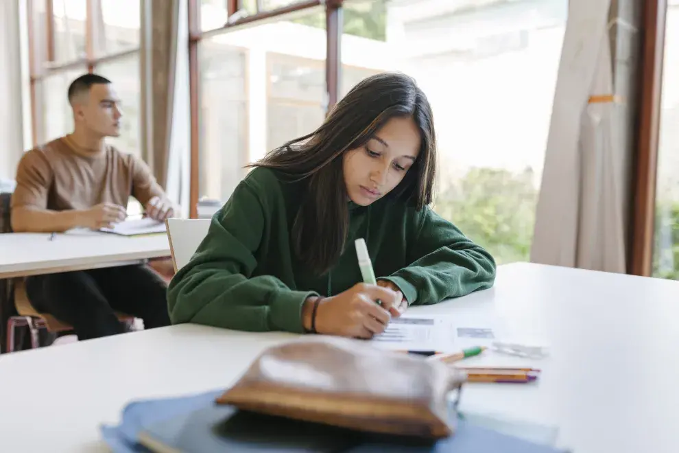 Una joven escribiendo en la escuela 