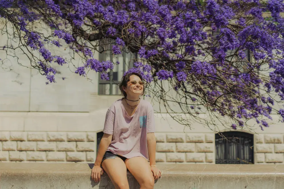 mujer frente a un jacarandá