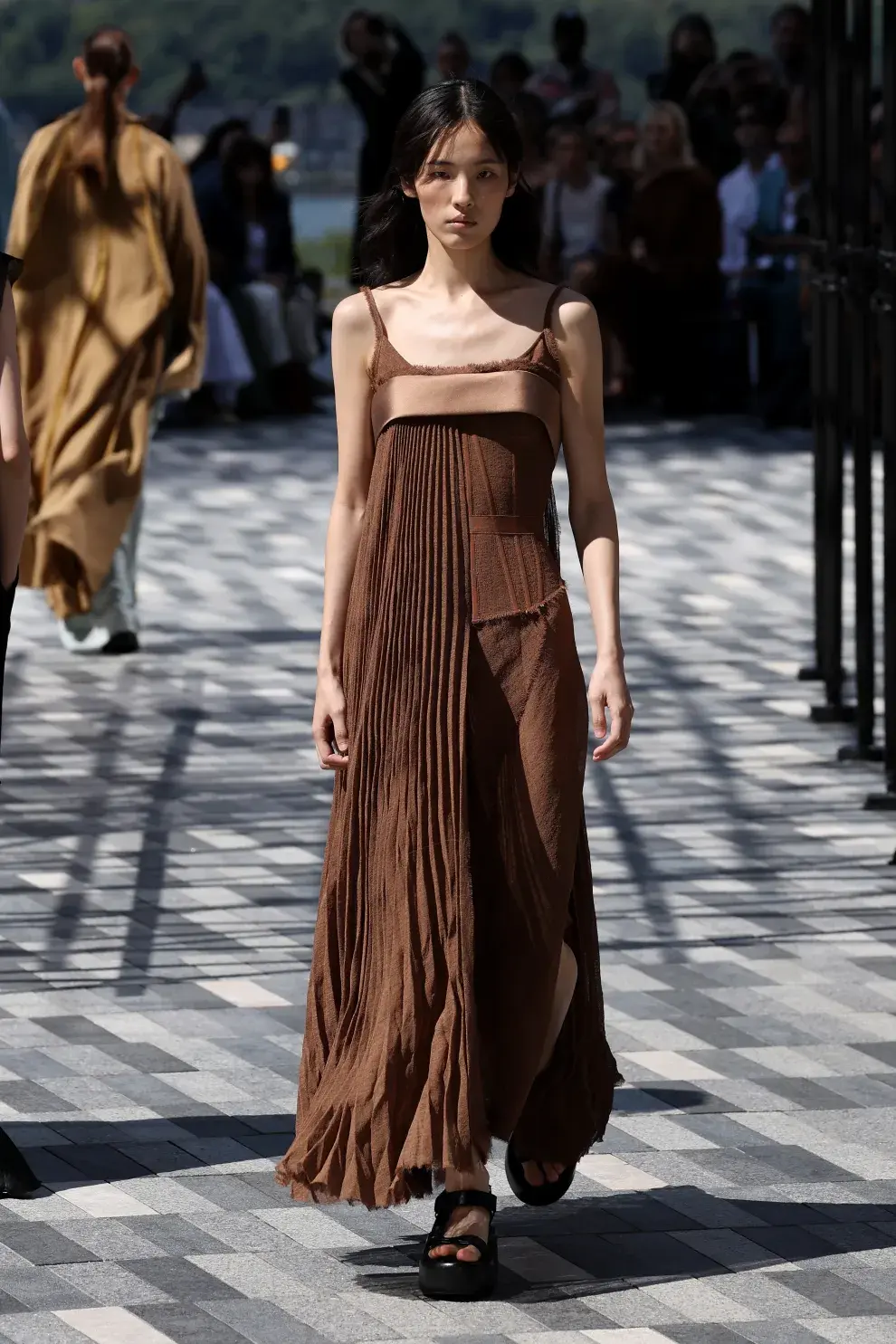 Una mujer caminando por la pasarela de Nueva York con un vestido color marrón