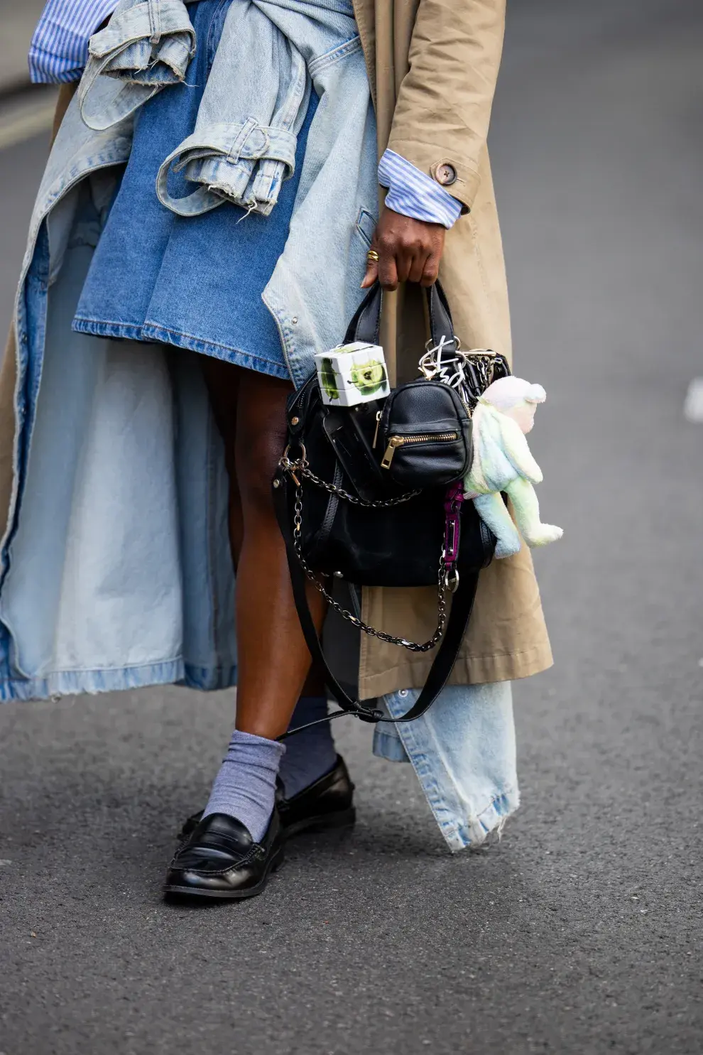 Una mujer caminando con una cartera repleta de Charms en la semana de la moda de Londres