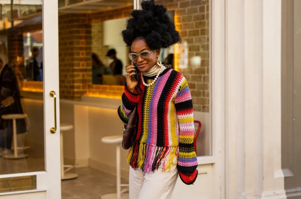 Una mujer posando en la semana de la moda de Londres con un sweater colorido 