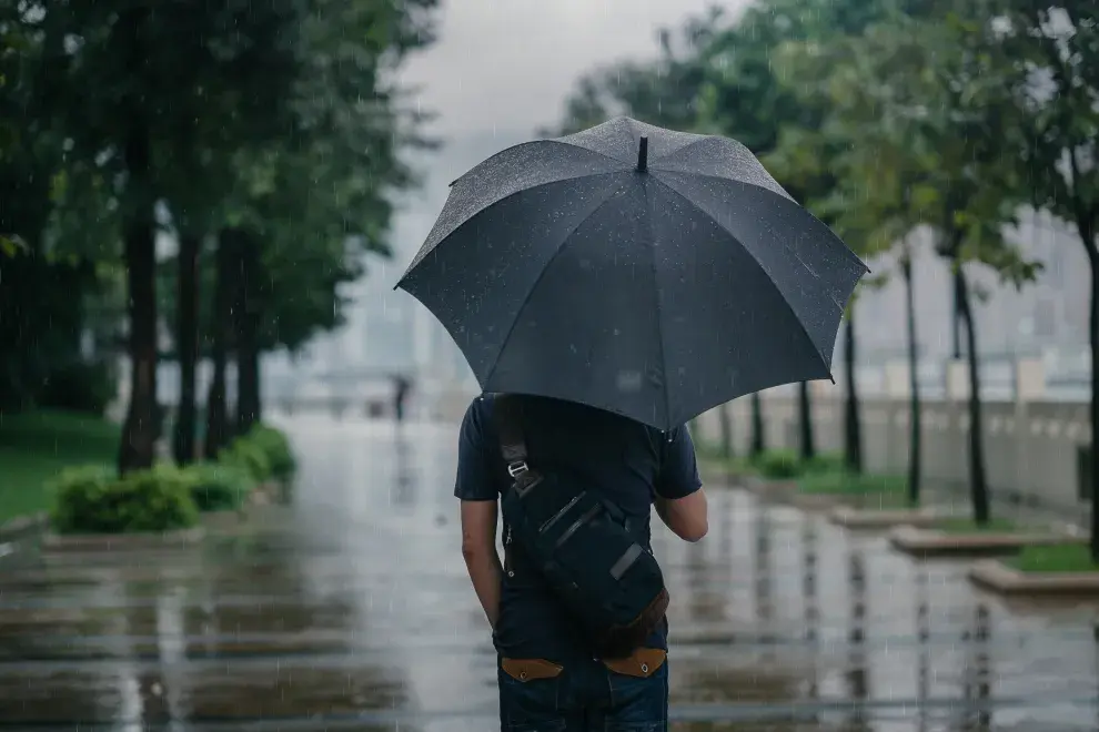 Hombre usando un paraguas debajo de la lluvia