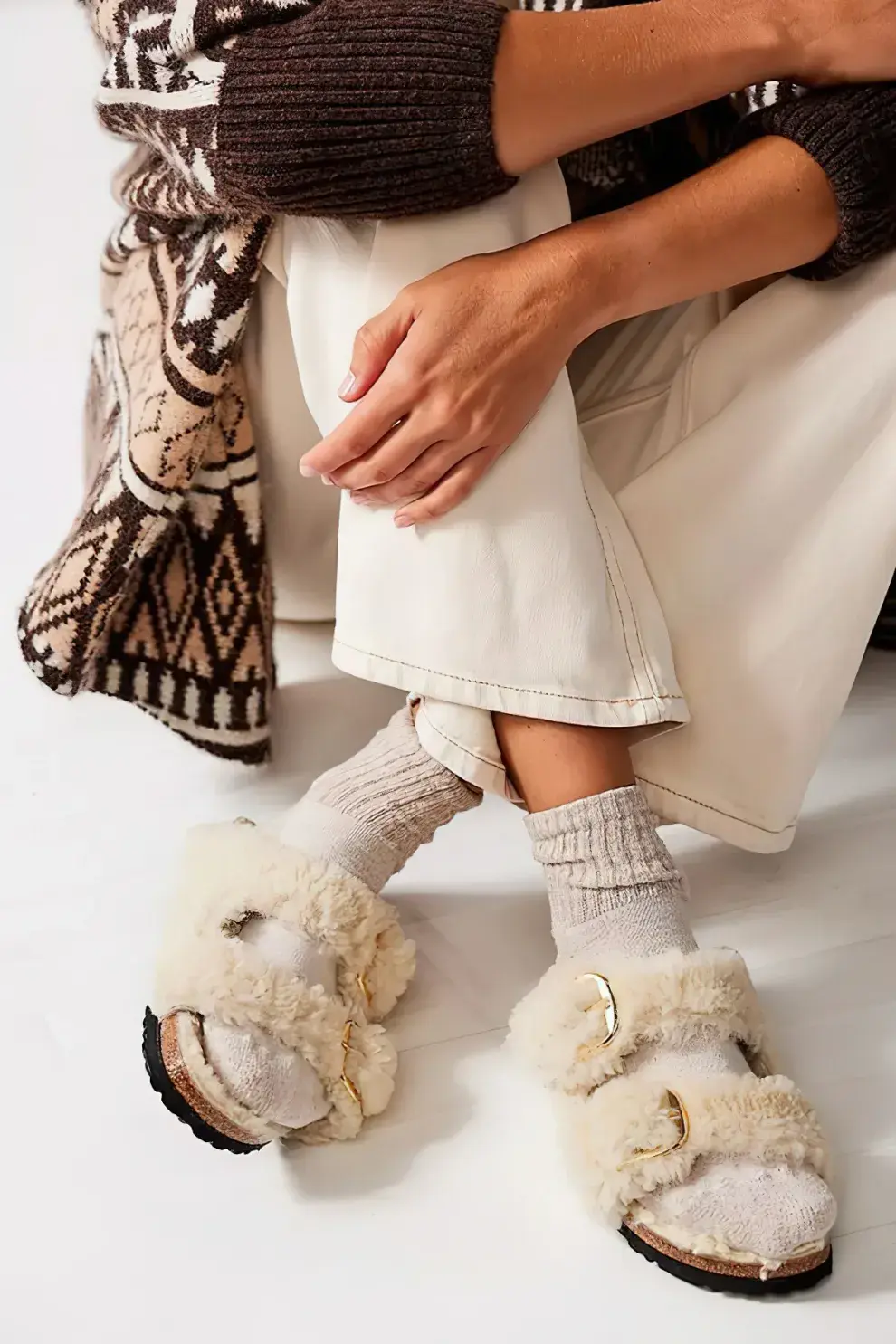 chica posando con sandalias Birkenstock y medias largas con un pantalón beige