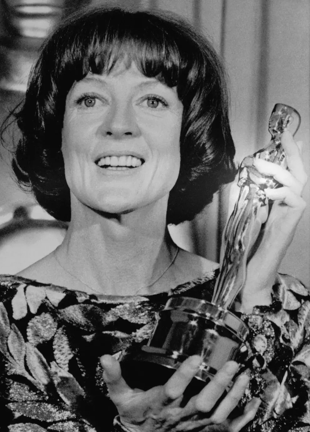 Foto en blanco y negro de Maggie Smith con su Oscar a Mejor actriz de reparto por California Suite.