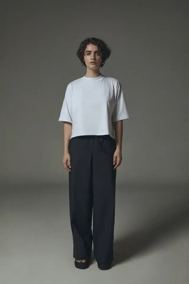 Foto de una modelo mujer usando una remera blanca.