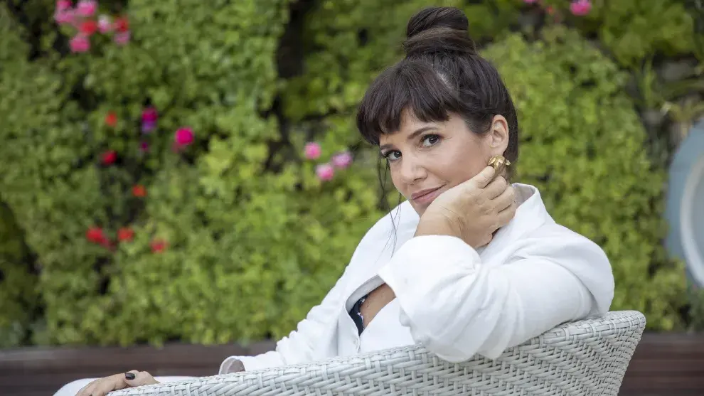 Griselda Siciliani sentada en un sillón en el jardín de su casa y rodeada de plantas