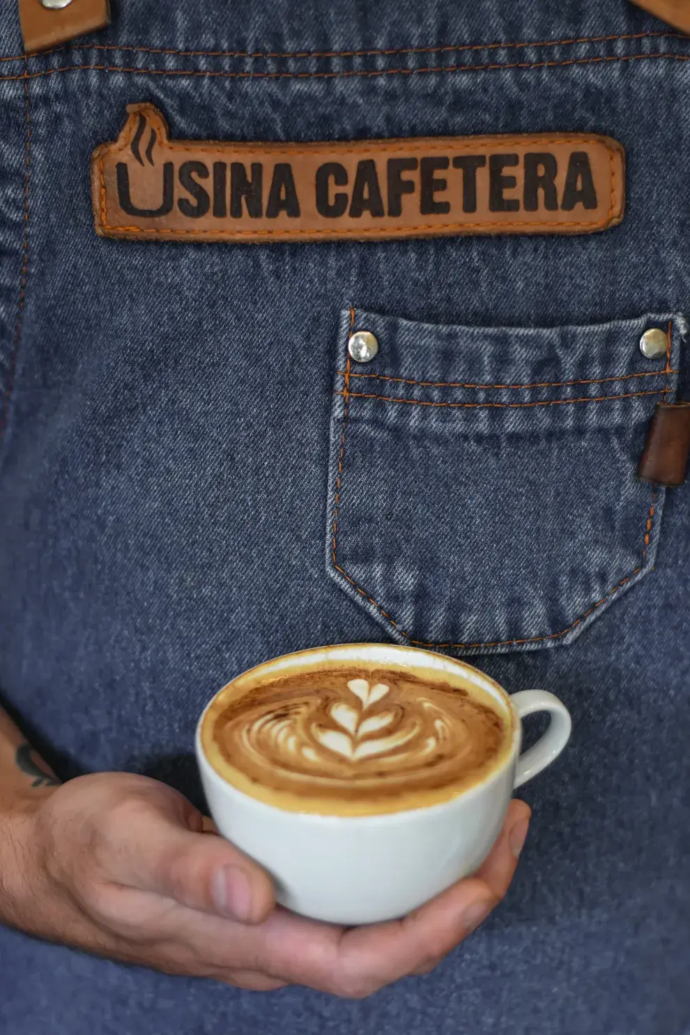 Un barista sosteniendo una taza de café de especialidad.