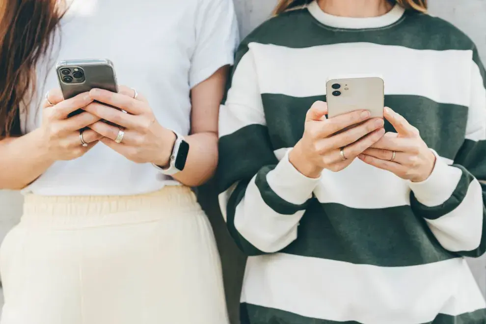 Dos mujeres usando su teléfono celular