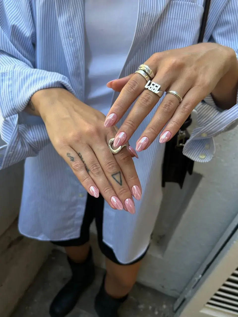 Foto de dos manos con una manicura rosa.