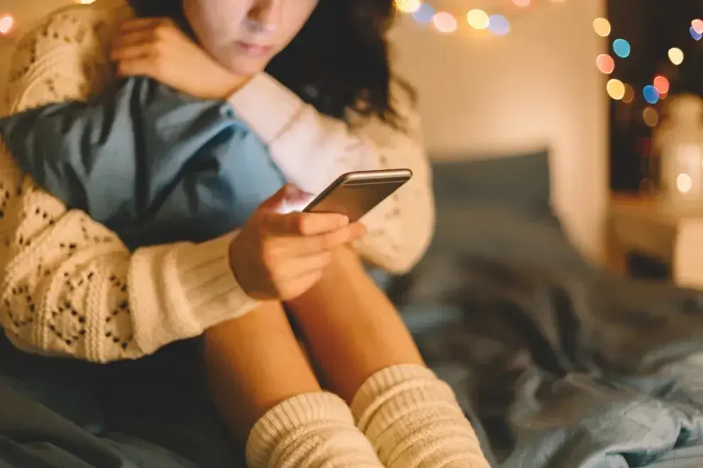 Una mujer mirando el teléfono celular