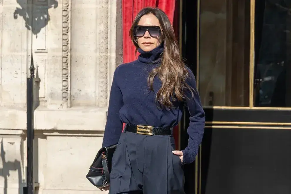 Victoria Beckham caminando por la calle con un look azul marino muy elegante