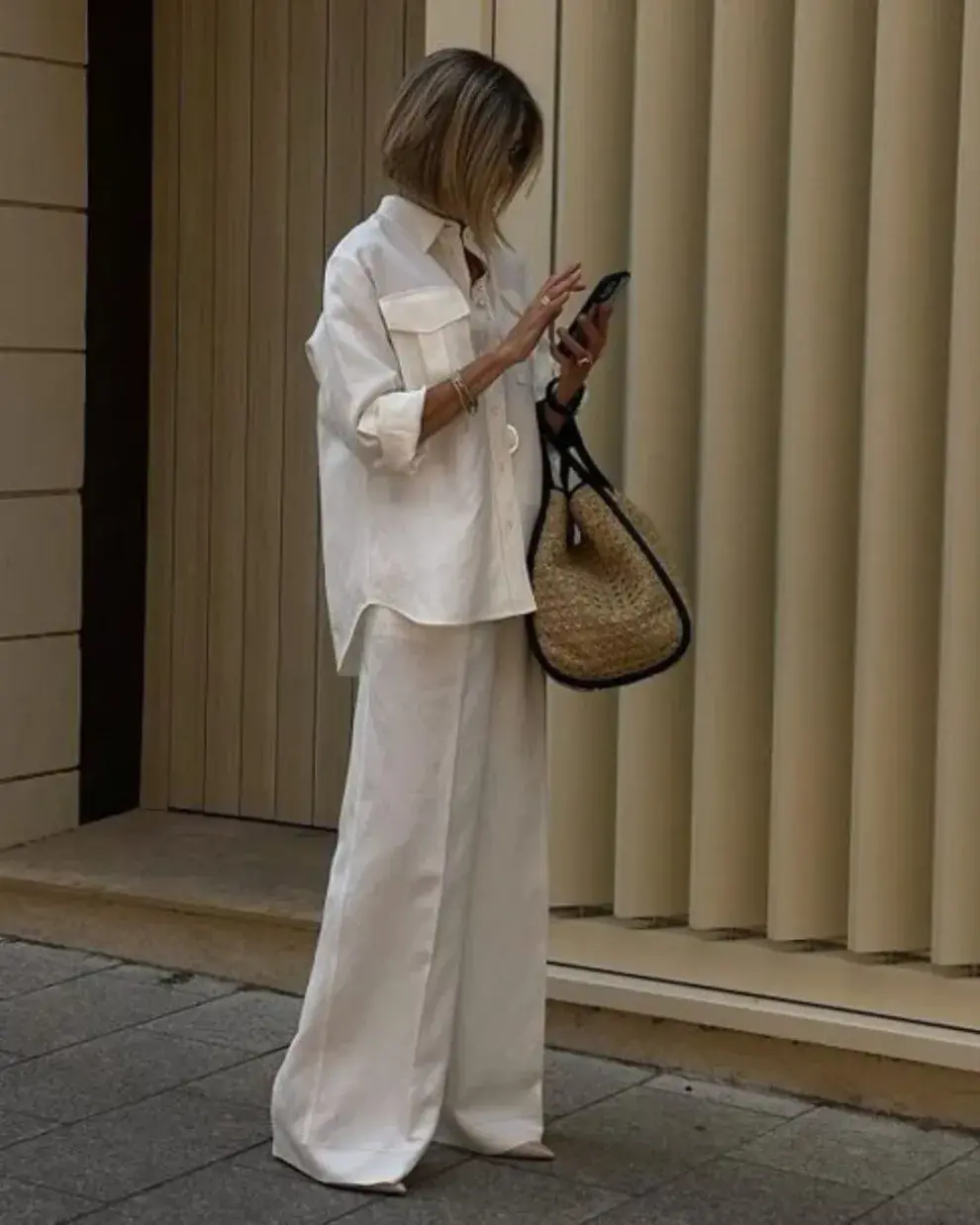 Una mujer en la calle usando un outfit de oficina para el verano.