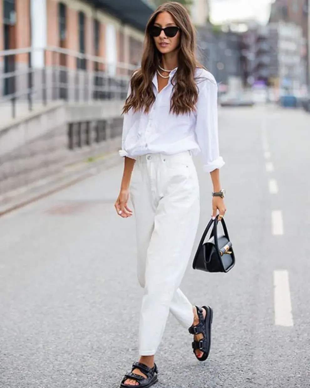 Foto de una mujer en la calle usando camisa blanca.