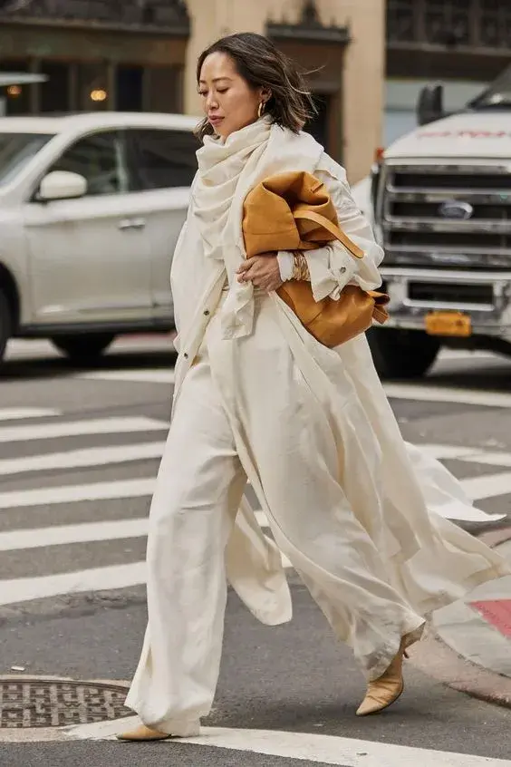 Foto de una mujer en la calle llevando un bolso XL bajo el brazo.