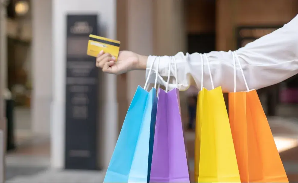 Una mujer con bolsas de colores en la mano 