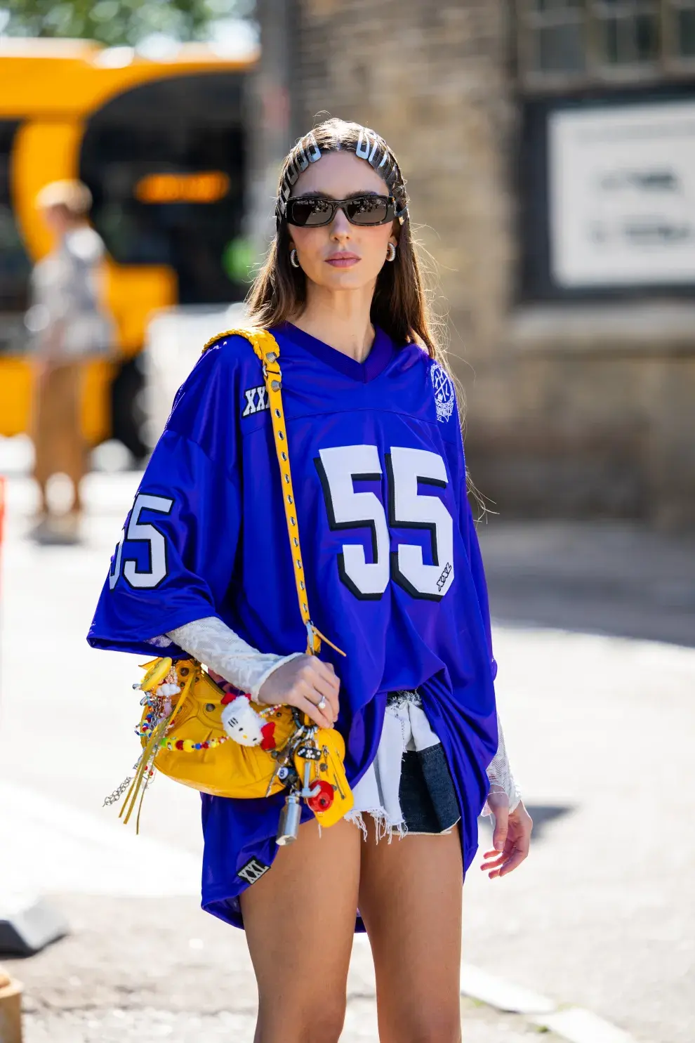 Una mujer usando una camiseta deportiva con una cartera en color amarillo