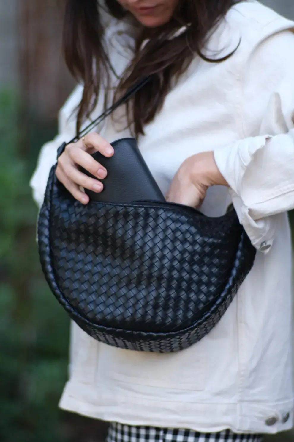 Foto de una modelo mujer usando un bolso trenzado.