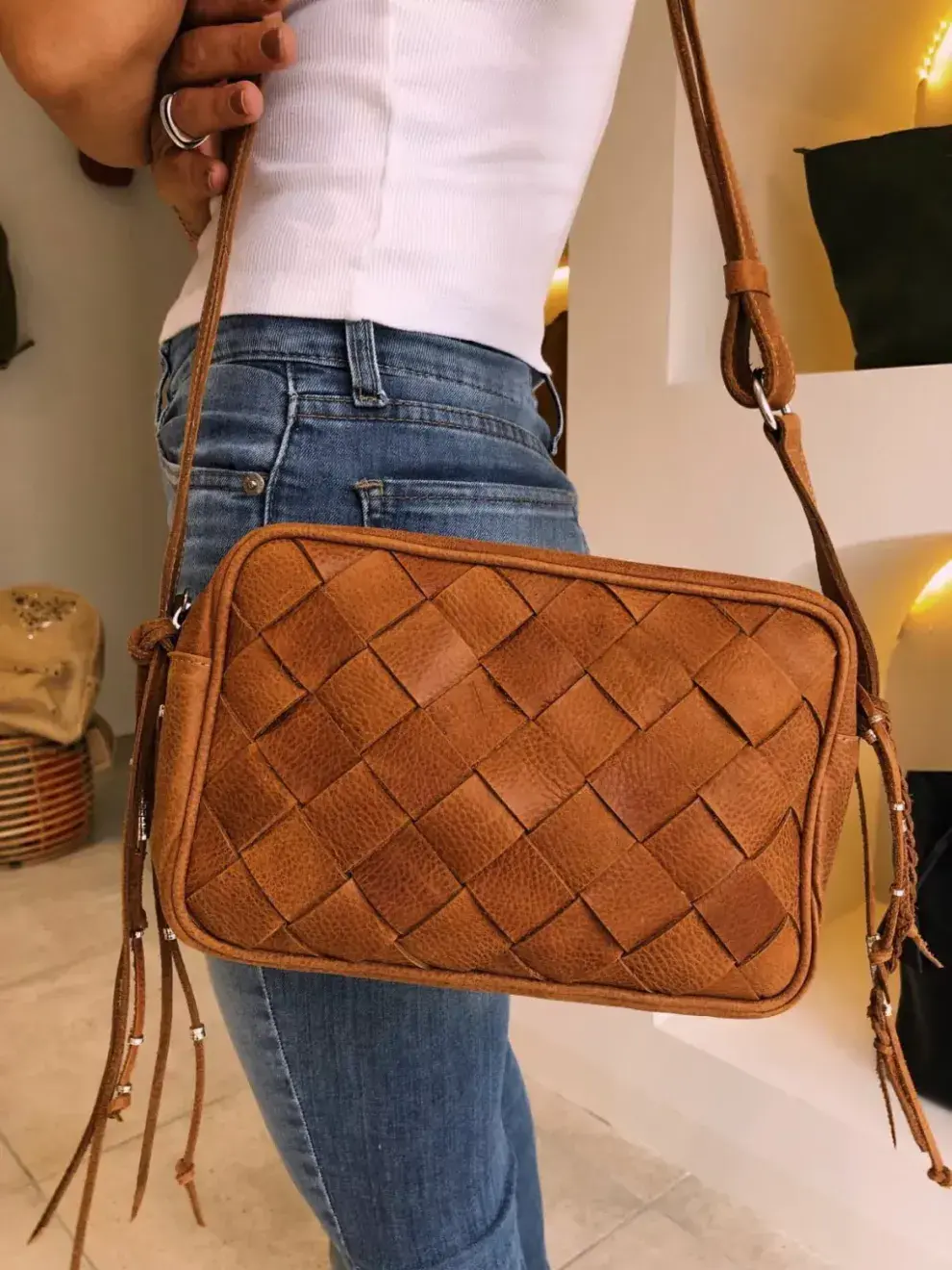 Foto de una modelo mujer usando una cartera trenzada.