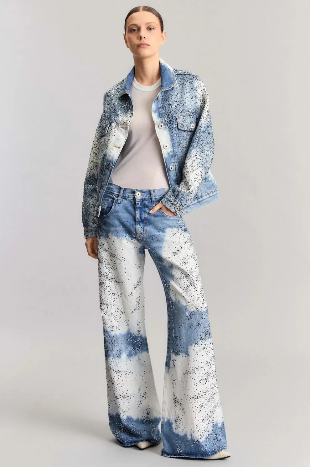 Una mujer posando con un jean de brillos batik