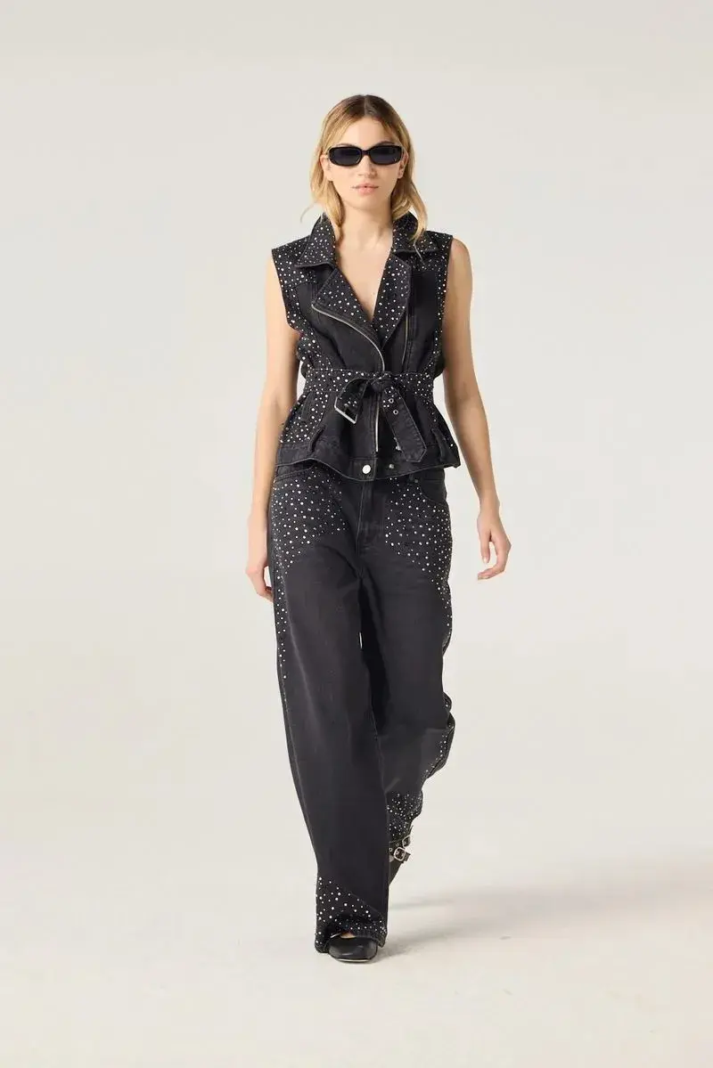 Una mujer usando un jean negro con apliques