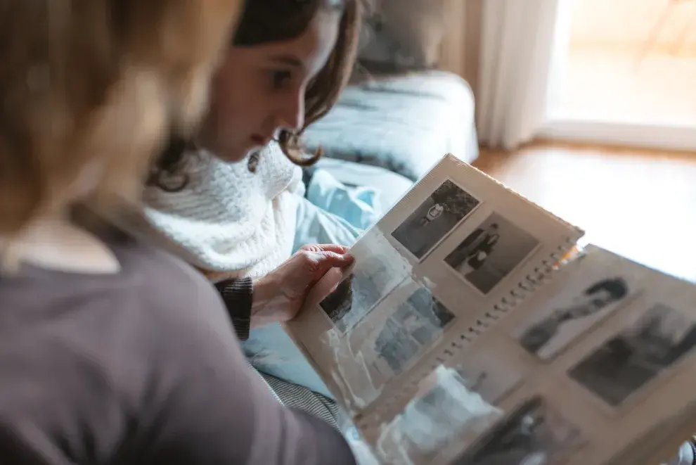 Niña y abuela miran un álbum de fotos