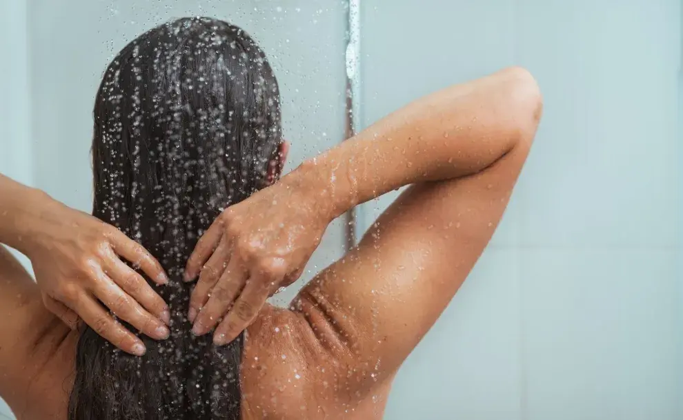 Una mujer lavándose el pelo