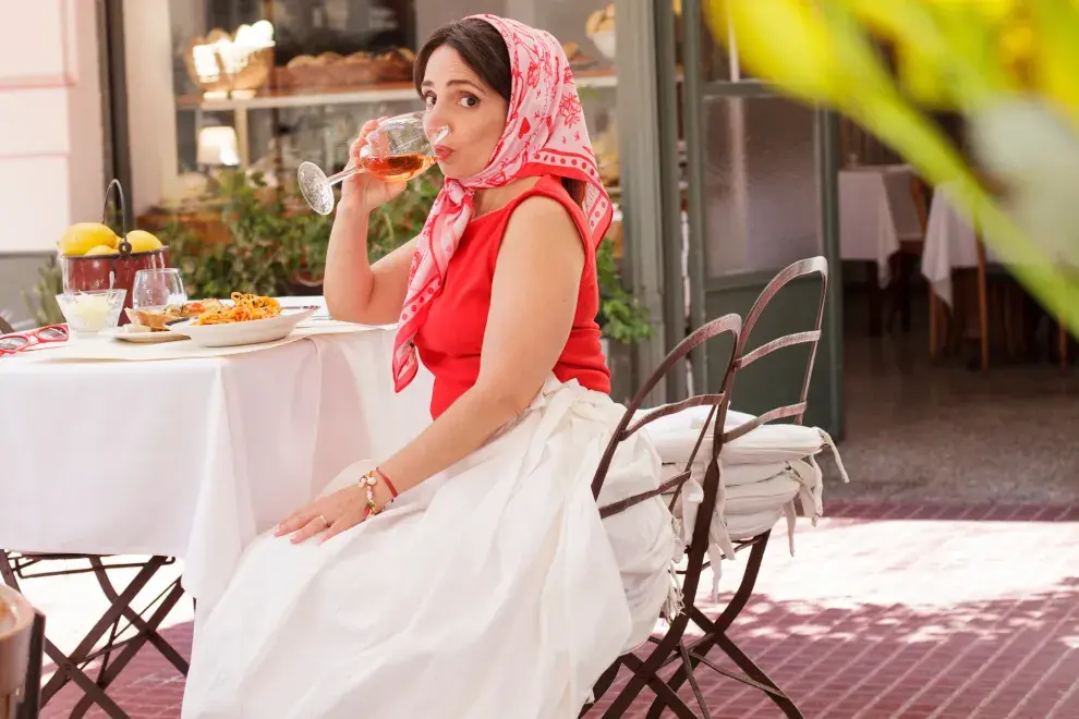 Paulina Cocina sentada tomando un vaso de vino.