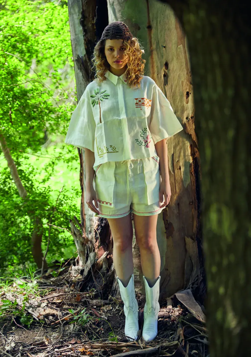 una chica posando en un bosque con ropa de verano