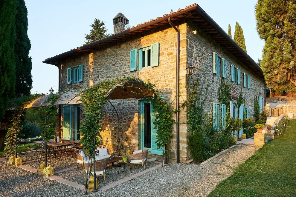 La pérgola de hierro, a tono con las sillas, comunica la cocina con el exterior de la casa.