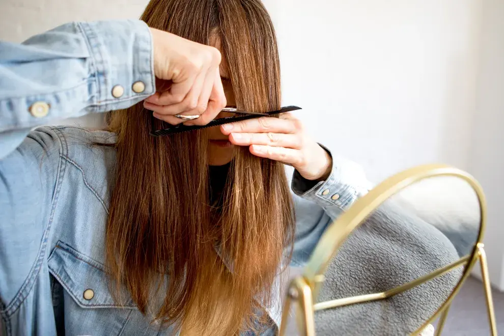 Una mujer cortándose el pelo