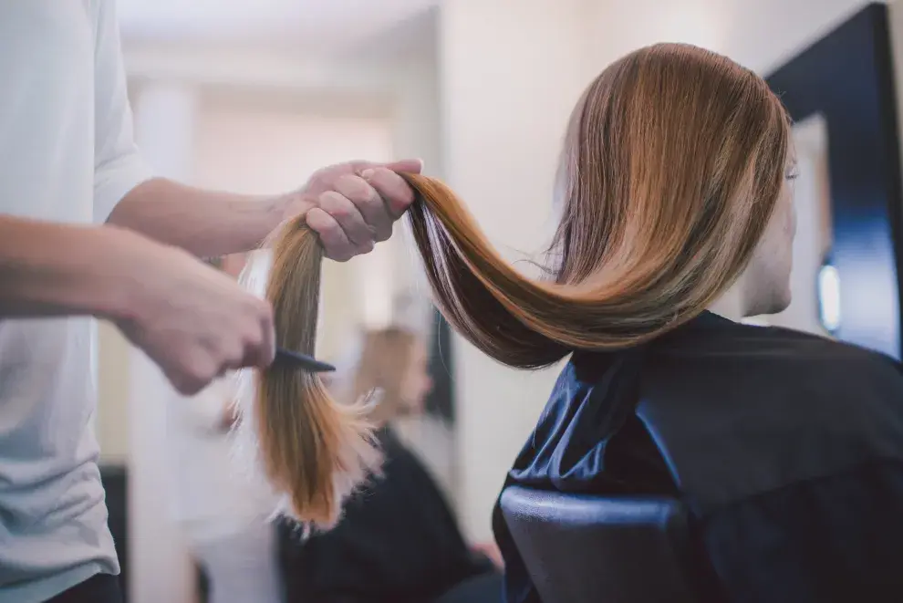 Una mujer en la peluquería cortándose el pelo