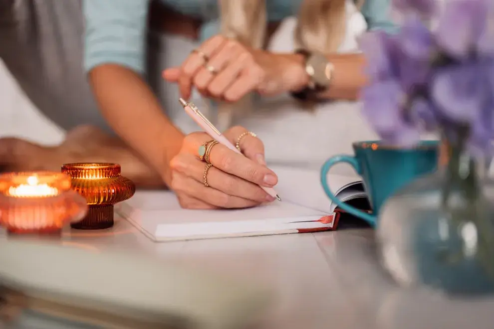 Una mujer escribiendo en un cuaderno.