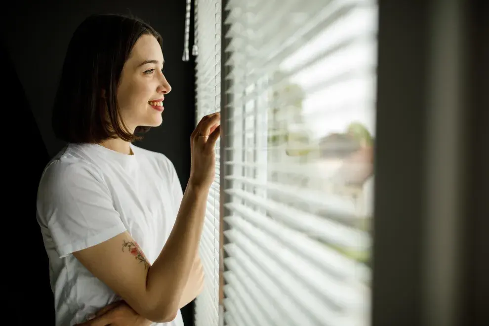 mujer mirando por la ventana