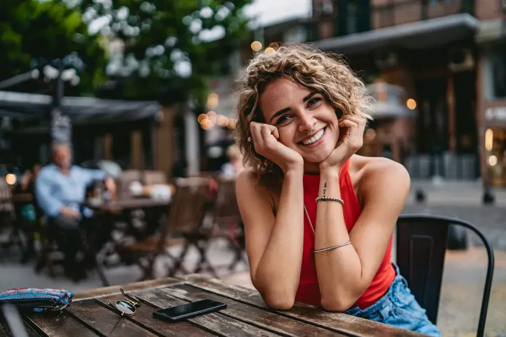 mujer tomando algo en un bar en la vereda