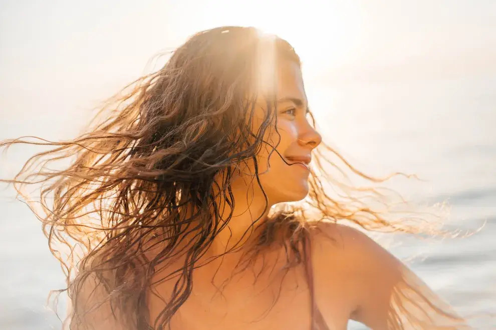 Una mujer con el pelo mojado disfrutando de un día de playa