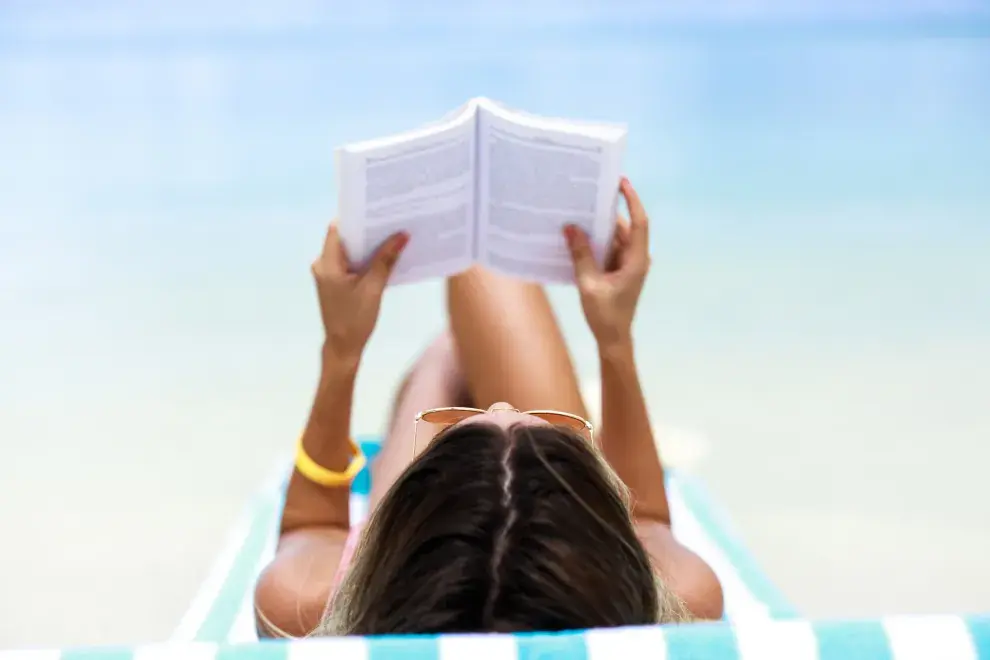 Una mujer leyendo en la playa