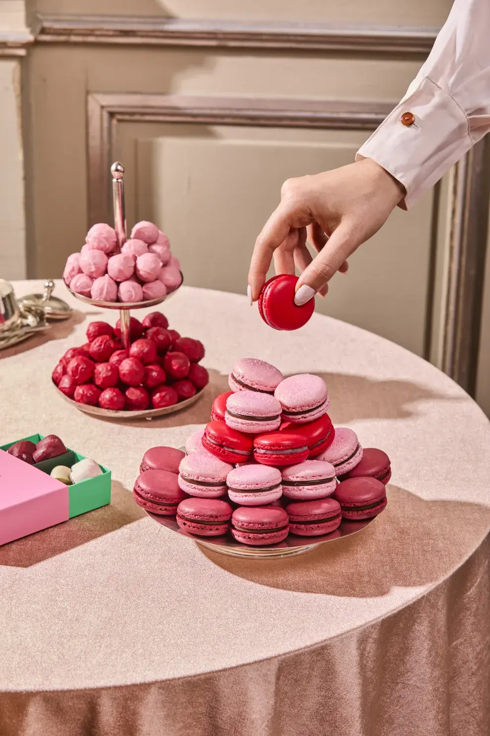 Bandeja de trufas y macarons en tonos de rosa.