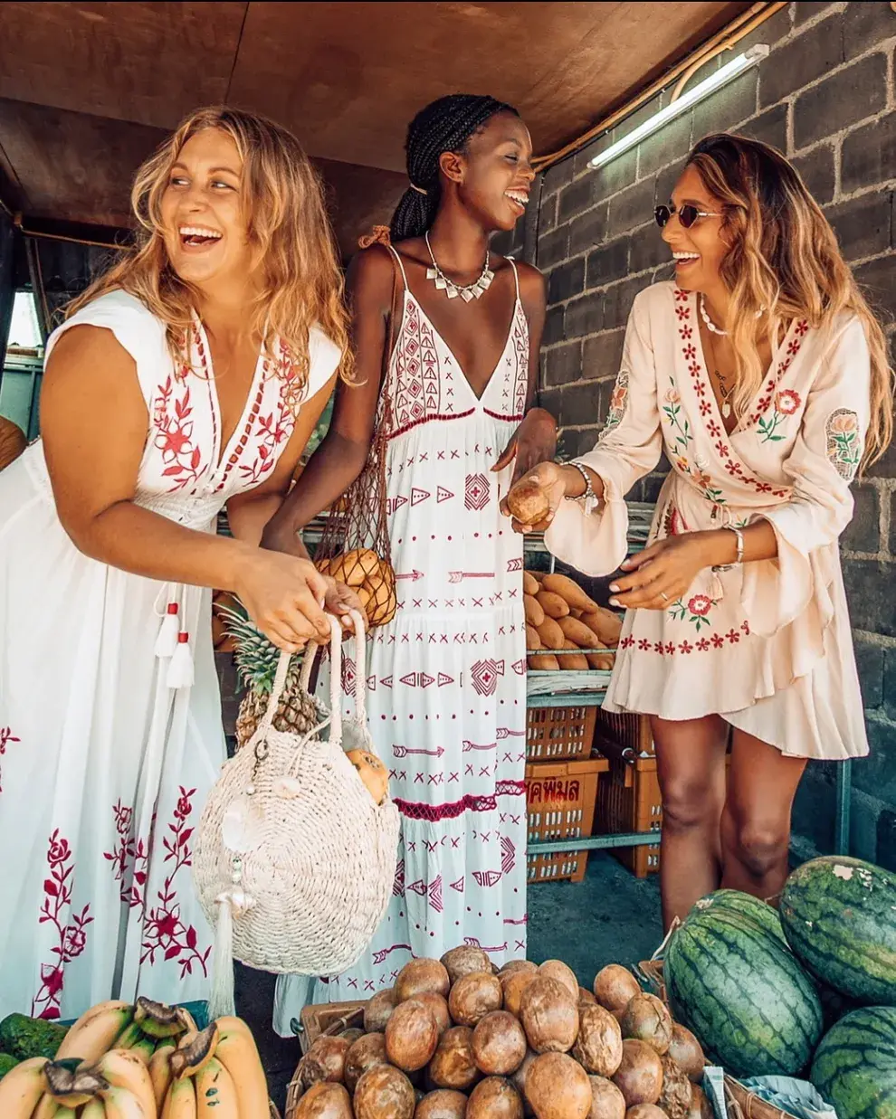 Tres mujeres posando con vestidos artesanales en colores blancos con vivos en rojo