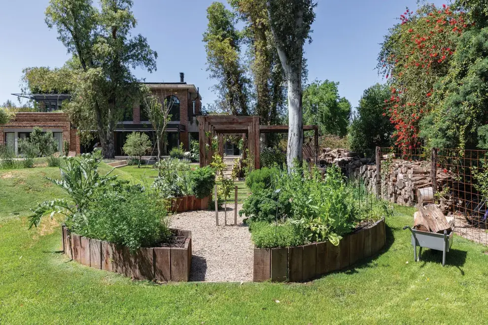 Un limonero ocupa el centro de la huerta circular que cuida personalmente la dueña de casa. Se trazó en eje con la cocina, el jardín de invierno y la pérgola.