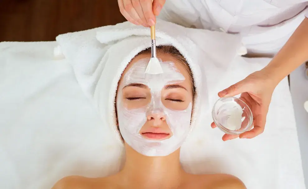 Una mujer haciendose una mascarilla facial