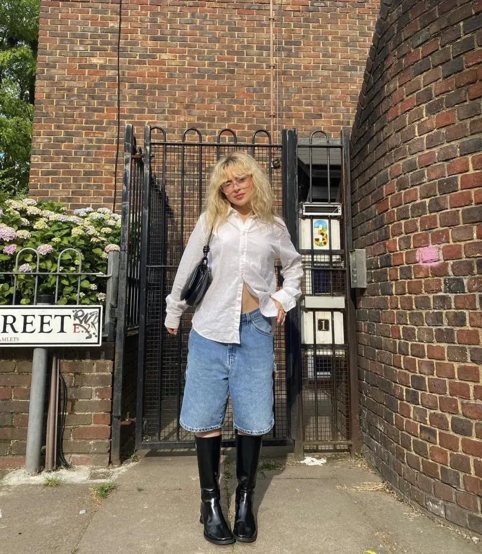 Sabrina carpenter con una camisa blanca, bermudas y botas altas