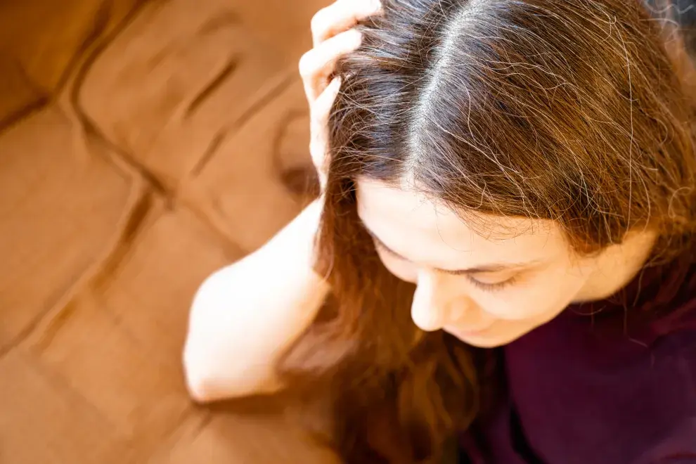 Una mujer con canas posando con su pelo largo